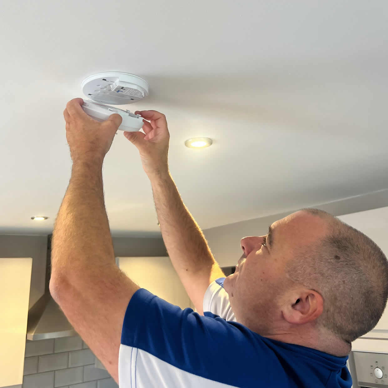 Smoke alarm being installed on a ceiling in Kidderminster